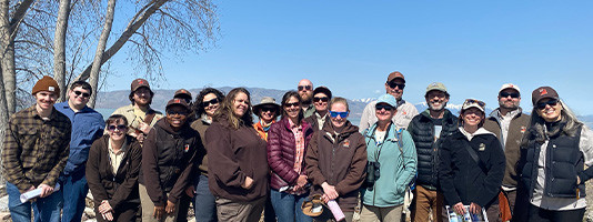 A group of scientists stand in a forest and observe nature.